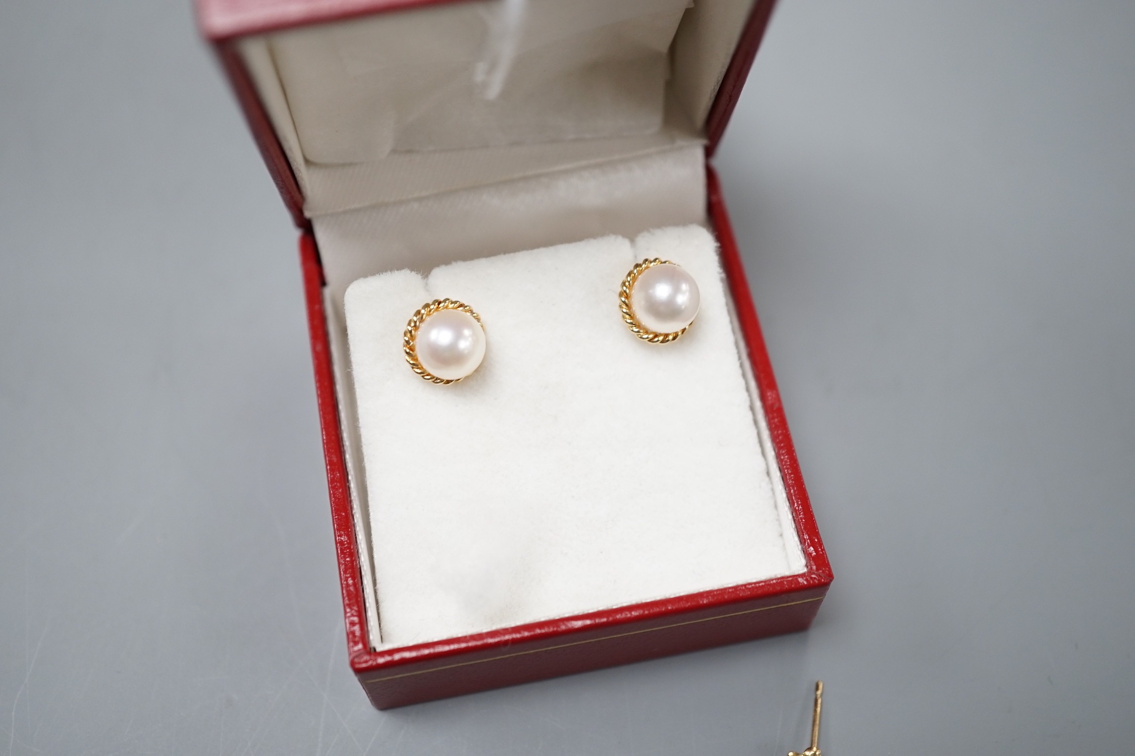 A modern pair of 585 yellow metal and cultured pearl ear studs, a pair of yellow metal and carnelian set drop earrings and a similar pair of cultured pearl earrings.